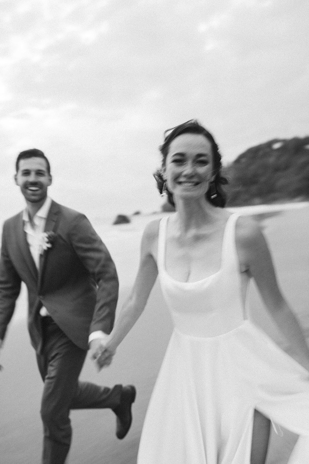 A joyful couple running together by the coast