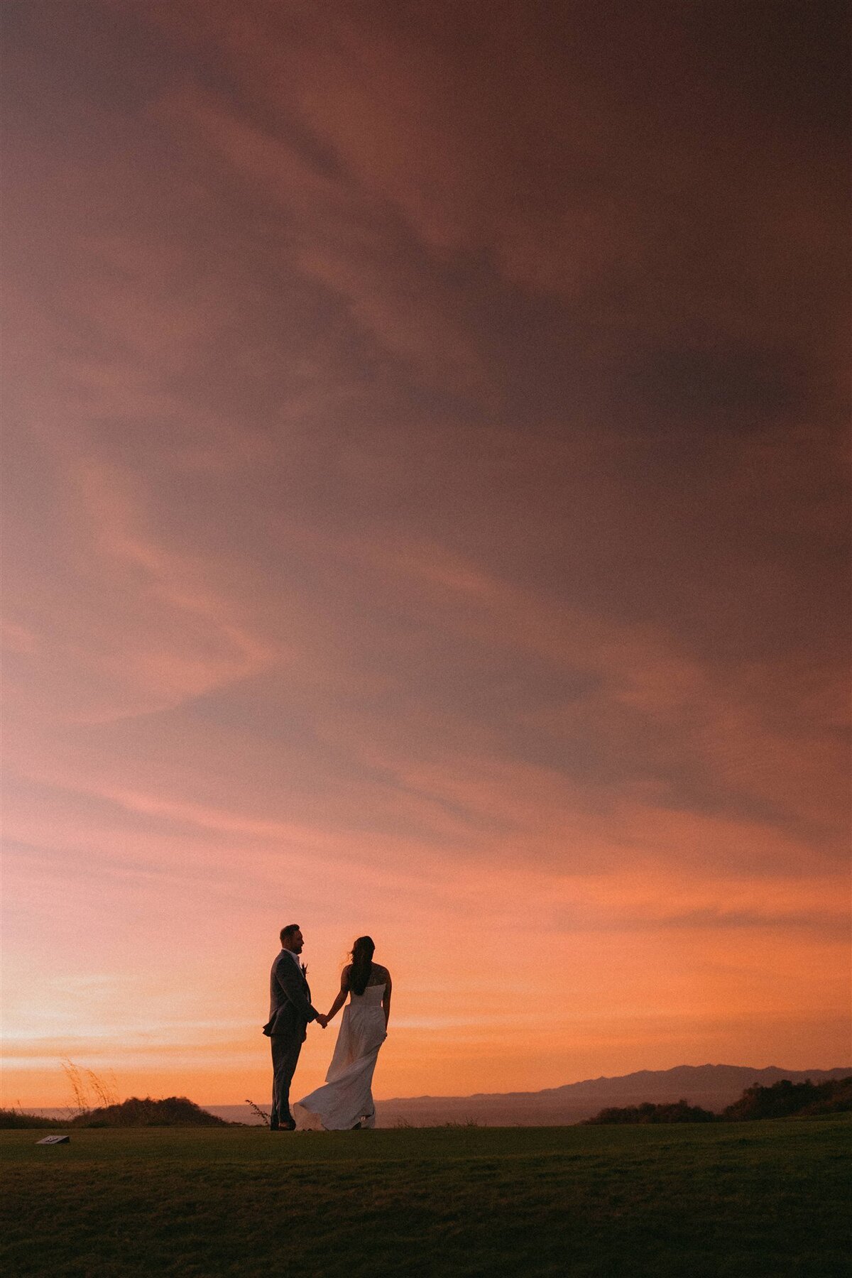 A couple beneath a warm sunset sky
